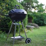 charcoal grill resting on garden lawn