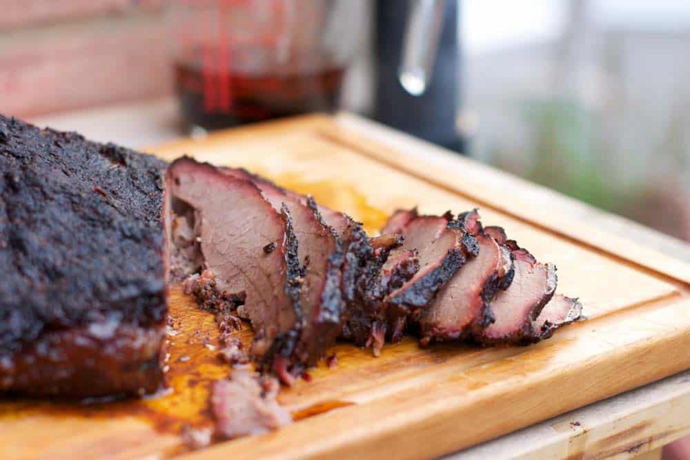 smoked brisket resting on chopping block