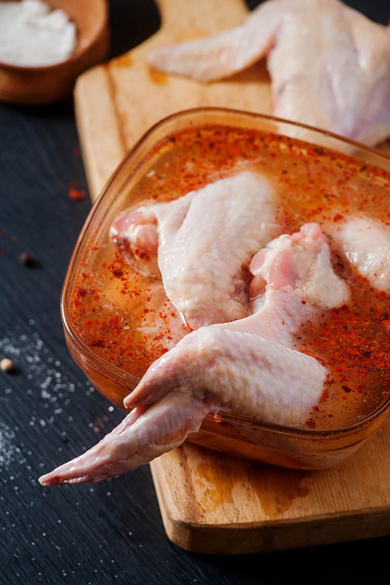 raw chicken wings submerged in spicy BBQ brine