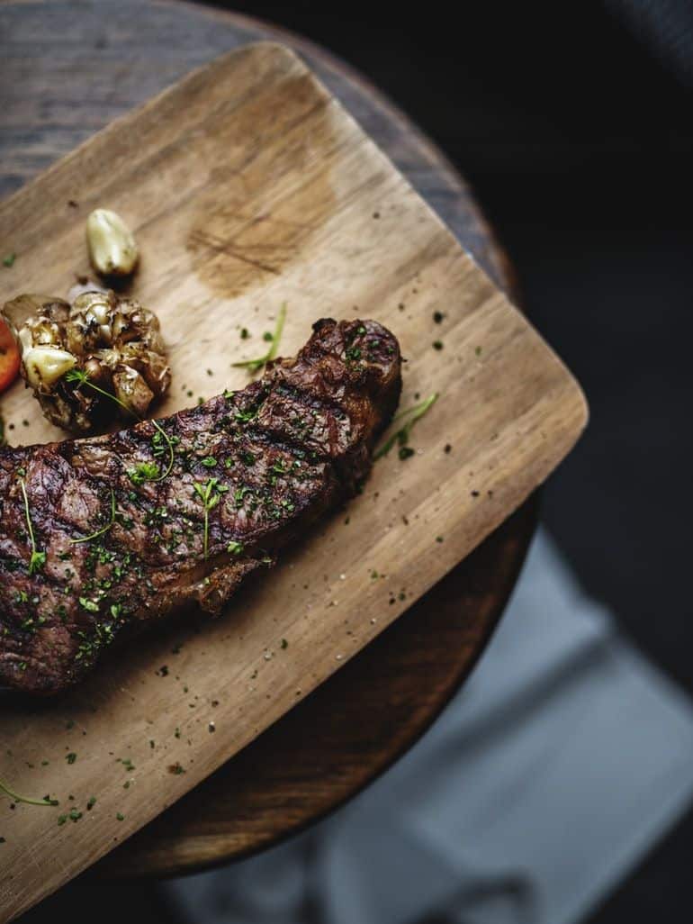 flank steak in seasoning on kitchen surface