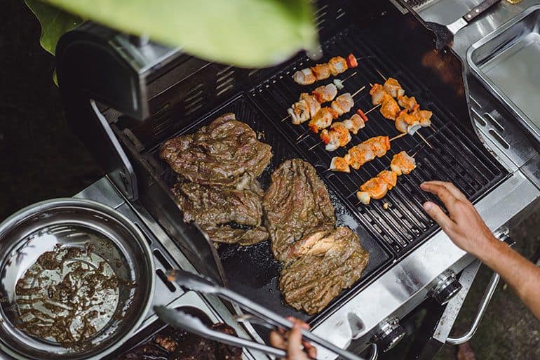 grilled meat cooking on large gas grill grates