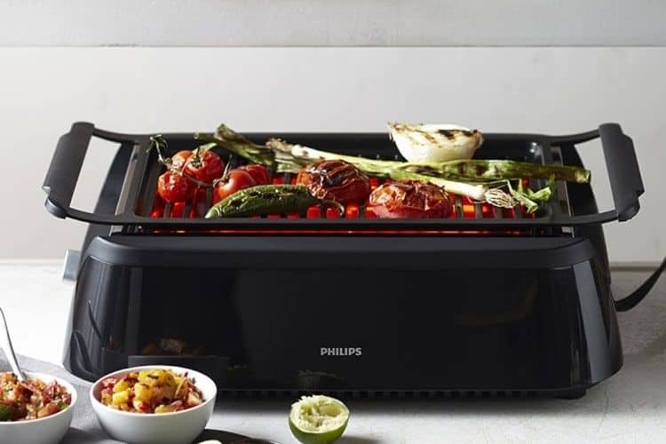 philips electric smokeless indoor grill on table surface with food cooking on top