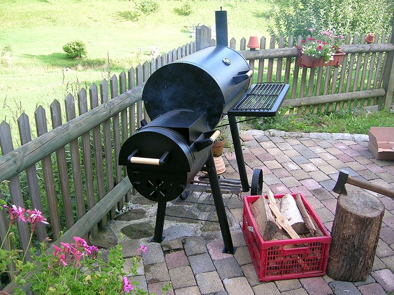charcoal offset smoker on outdoor patio