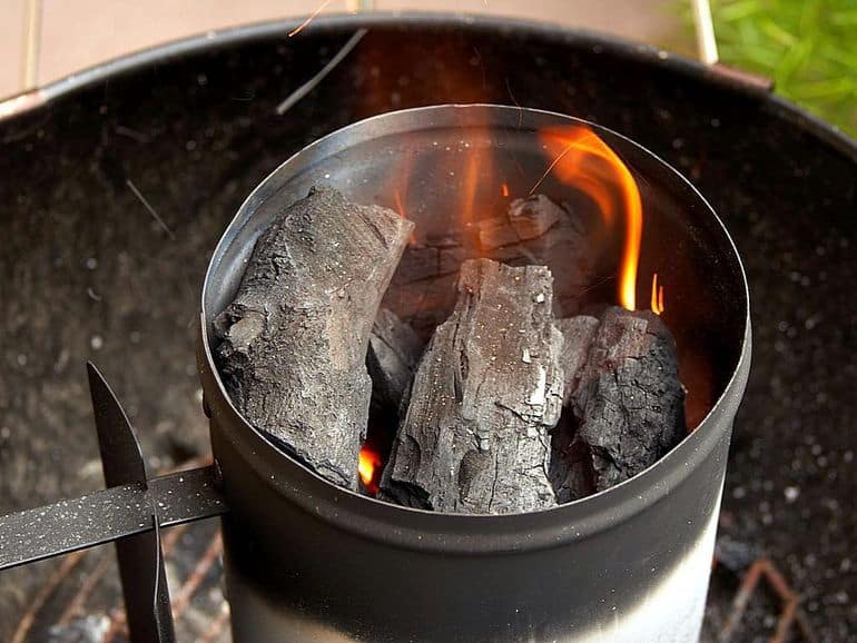 chimney starter filled with burning charcoal