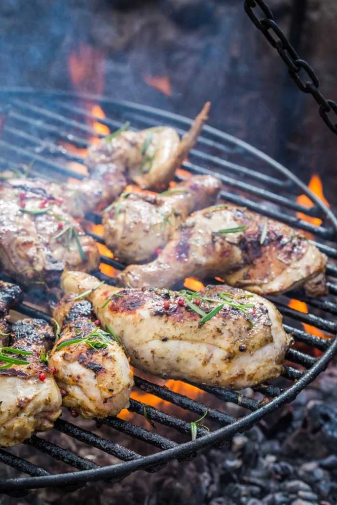 chicken thighs and legs cooking on grill
