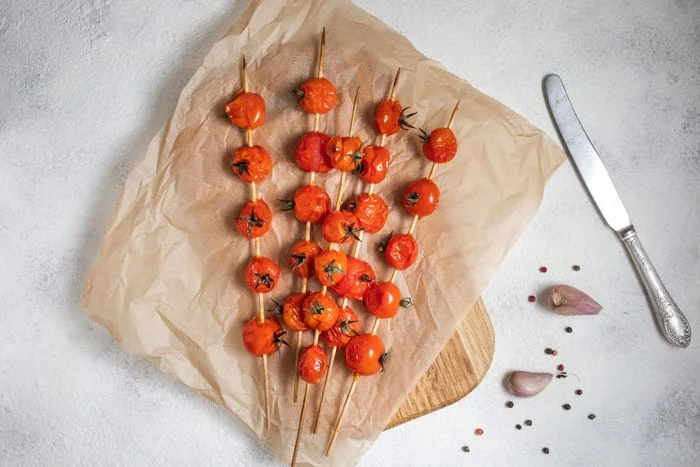 grilled tomatoes resting on parchment paper