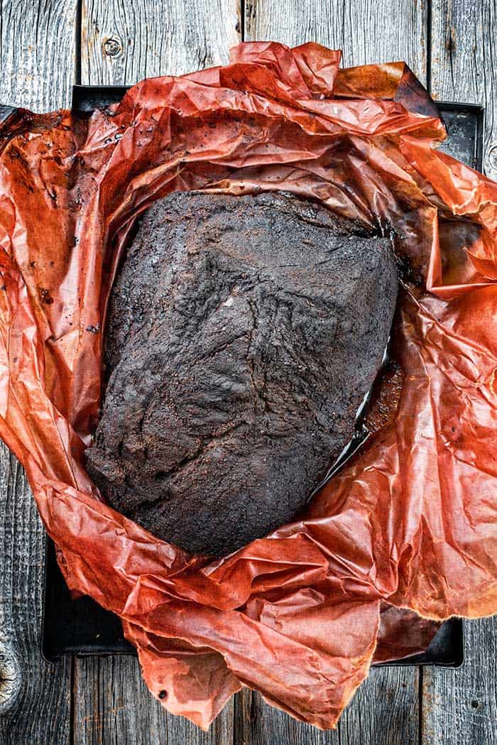 barbecue smoked brisket resting in pink parchment paper