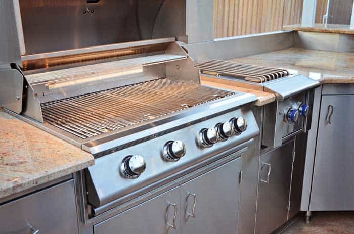 drop in gas grill placed in outdoor kitchen bbq island