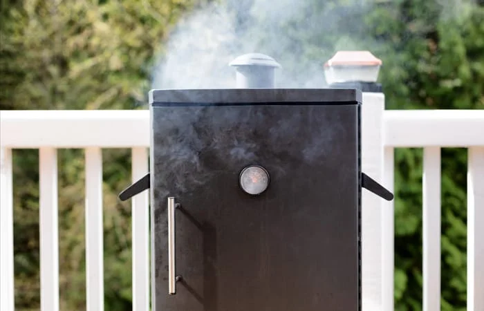 electric smoker turned on and with smoke pouring out