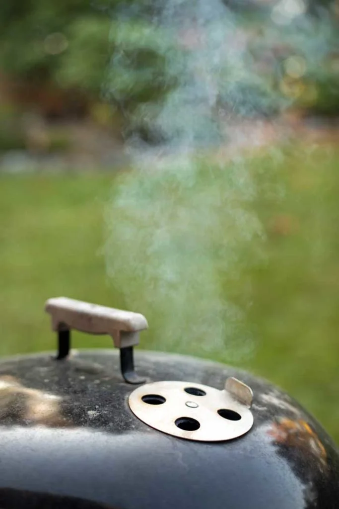 charcoal grill vents wide open to allow smoke to pass out