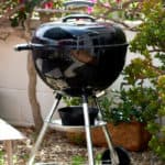 weber kettle charcoal grill on patio garden