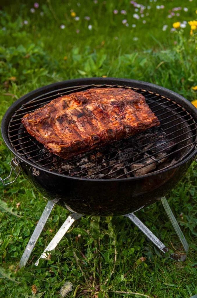 pork ribs cooking on charcoal barbecue grill