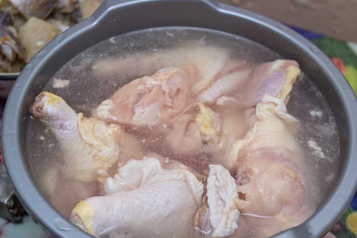 frozen chicken thawing in bowl of warm water