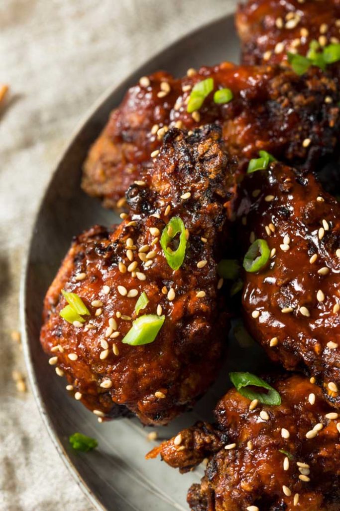 smoked korean bbq chicken wings with sesame seeds resting on plate