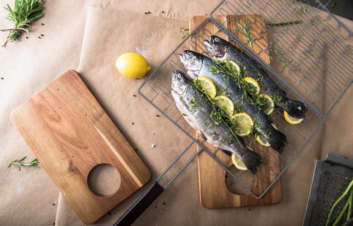 fish and lemon in grill basket before cooking, resting on cooking surface