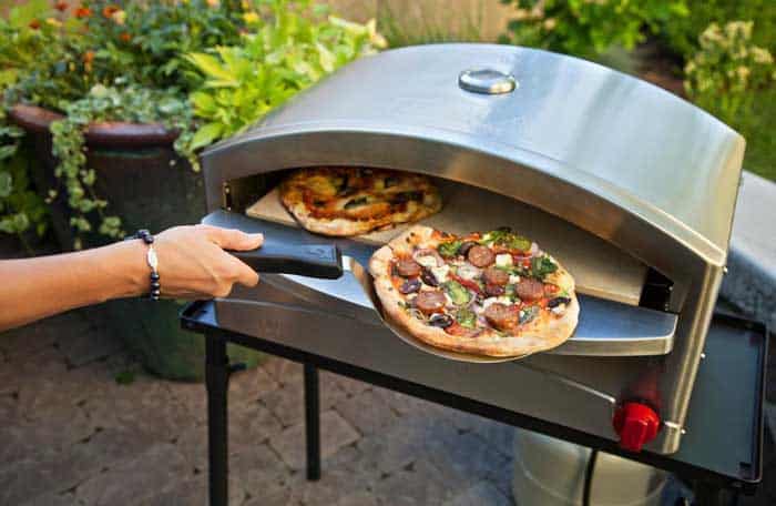 Camp Chef Italia Artisan Pizza Oven in backyard cooking homemade pizza