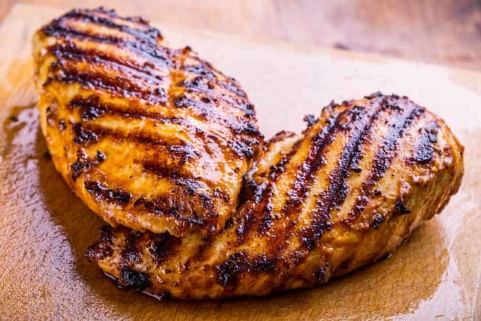 Grilled chicken breast in different variations on a wooden board