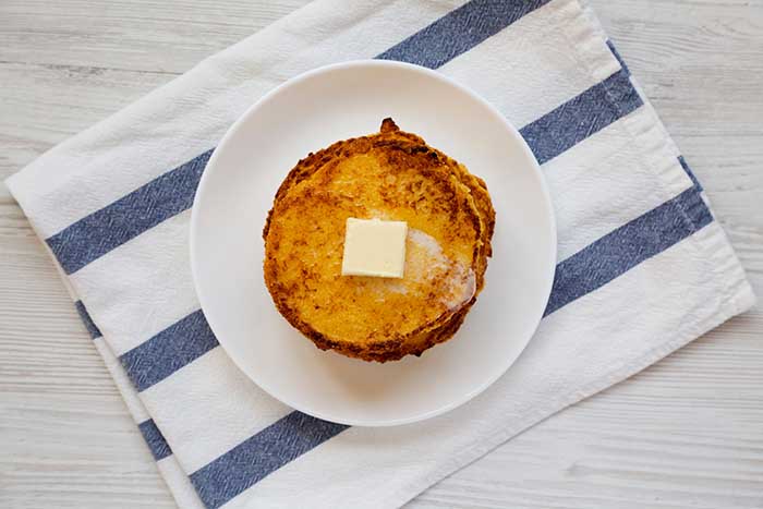 Homemade corn meal Johnny cakes with butter on a white plate