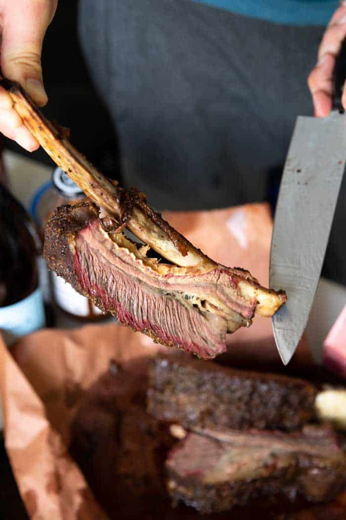Slow cooked barbecue beef rib held with a knife