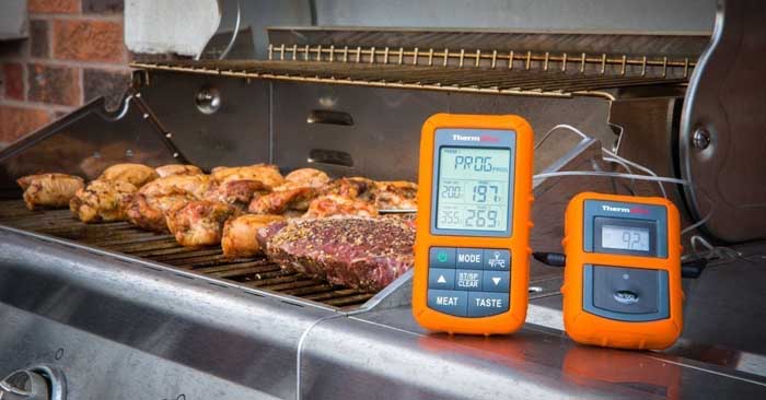 thermopro tp20 next to grill cooking meat