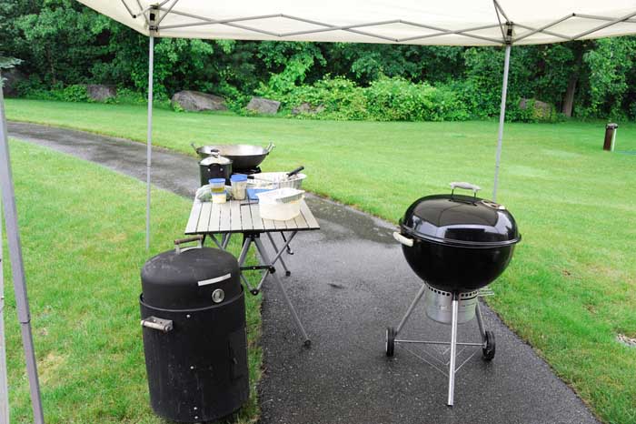weber kettle grill and portable table under large pop-up canopy for shelter from rain