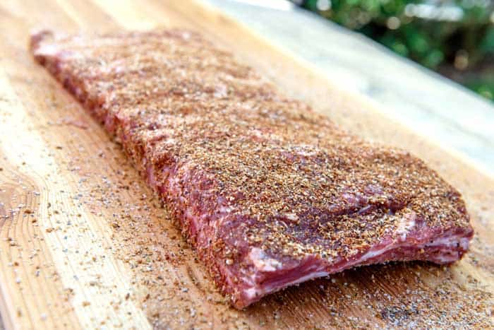 closeup of raw venison ribs with bbq rub seasoning