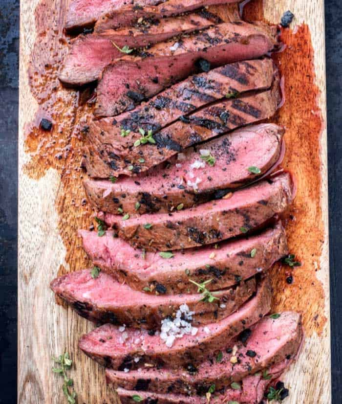 beef bavette steak sliced and served on chopping block