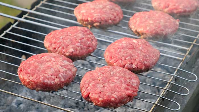 beef burger patties on grill grates