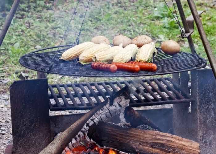 campfire grilling grate over lit fire log coals