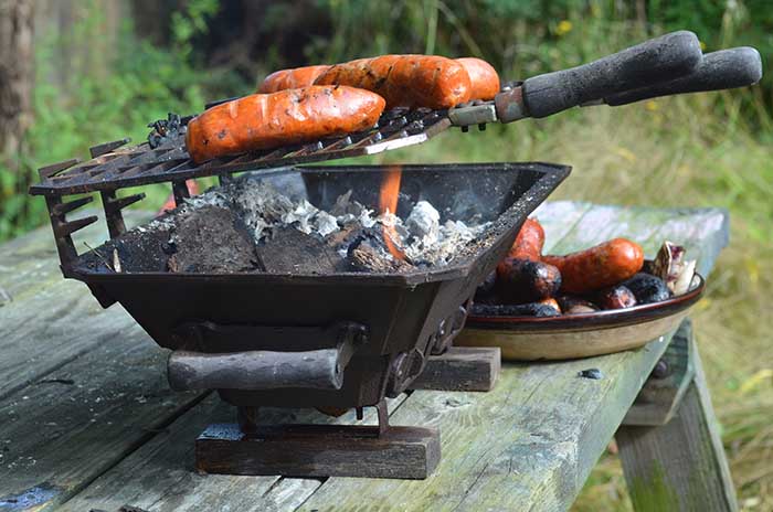 Close up and side view of sausages grilling on HIbachi tabletop grill