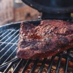 charred barbecue smoked beef brisket on smoker grill grates