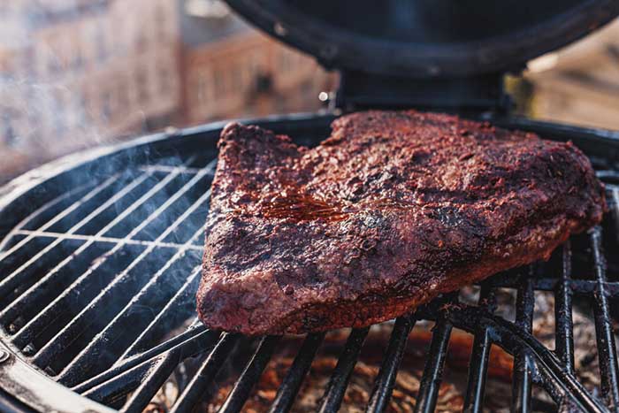 charred barbecue smoked beef brisket on smoker grill grates