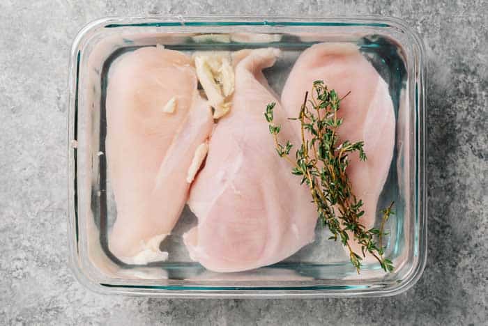 chicken breasts soaking in brine with thyme