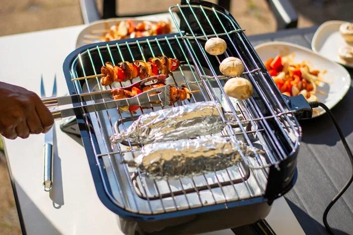 https://theonlinegrill.com/wp-content/uploads/electric-smokeless-grill-with-tong-and-aluminum-foil.jpg.webp