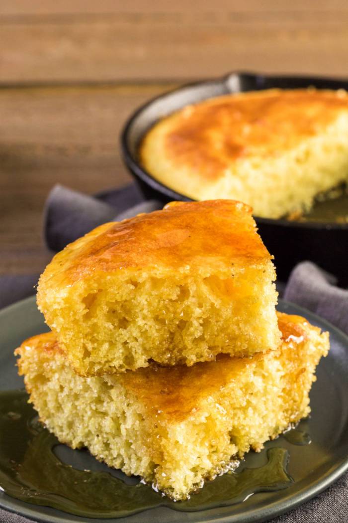 grilled skillet cornbread sliced to serve and drizzled in homemade hot honey butter