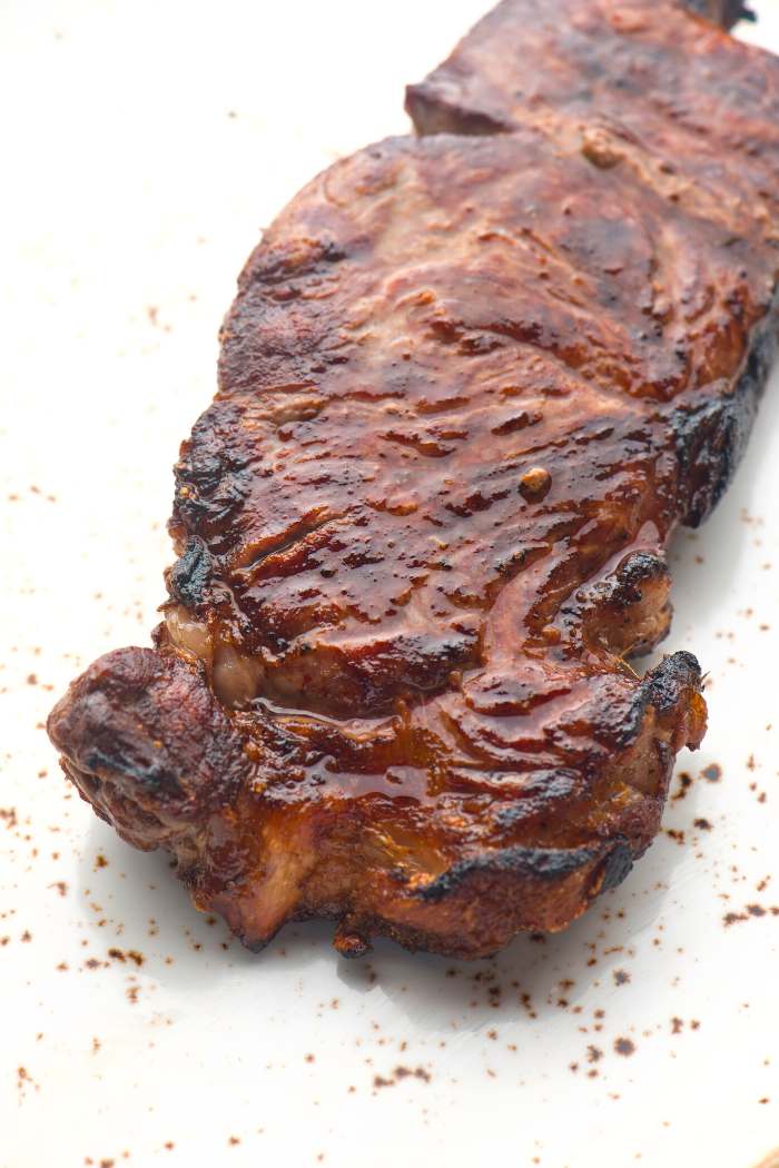close-up of grilled elk steak on white background