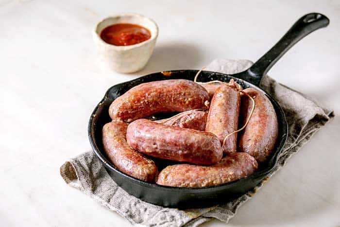 grilled italian sausages salsiccia in cast-iron pan