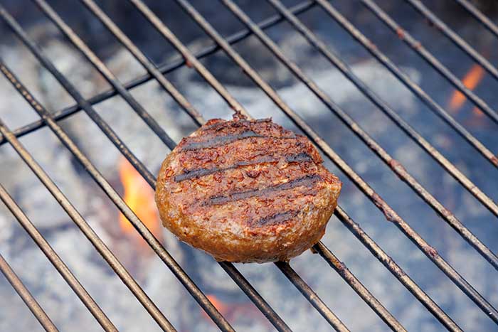 hamburger cooking on grill grates