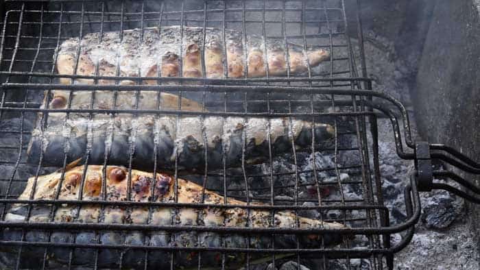 backyard smoked mackerel in grill abskets over low heat charcoal