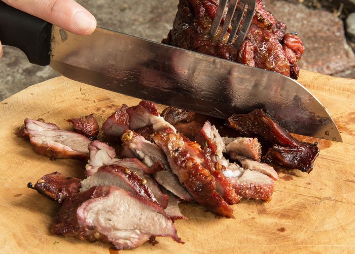 knife slicing smoked pork