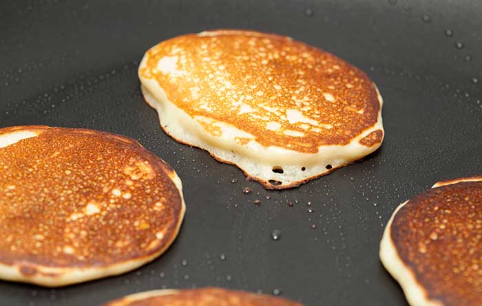 making thick pancakes on dark griddle surface