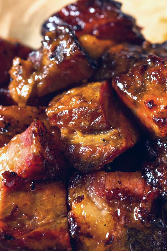 close-up of smoked chuck roast burnt ends covered in barbecue sauce