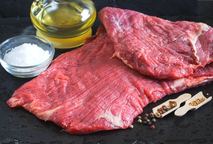 raw beef flank steak showing prominent muscle fiber grain direction