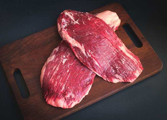 raw flank beef on a wooden Board top view