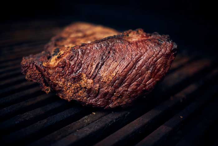 beef top round cooking on smoker grates