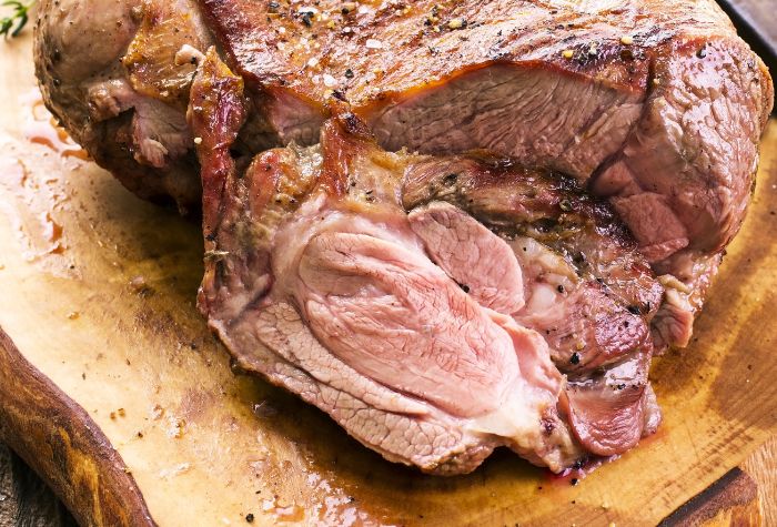 smoked leg of lamb served on wooden chopping block