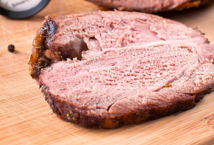 sliced smoked leg of lamb showing meat and barbecue bark