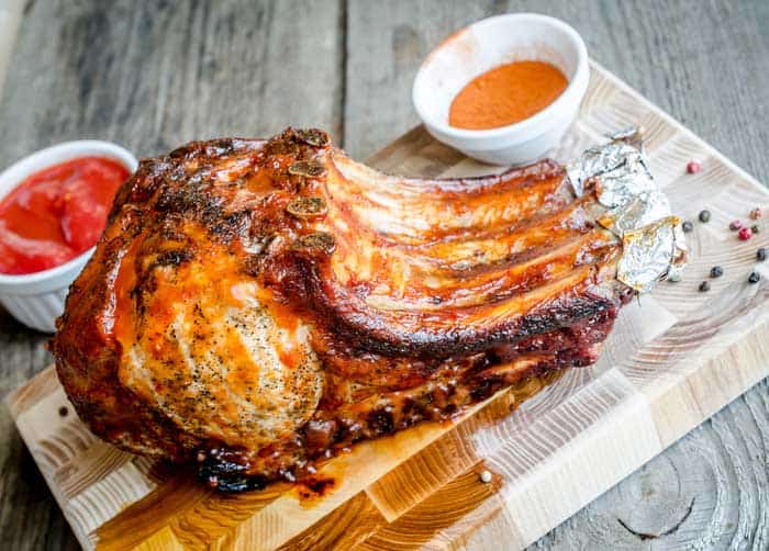 smoked rack of pork on chopping board with bbq sauce