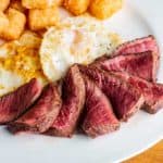 steak medium rare with eggs sunny side up potato hash side dish