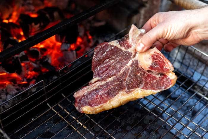t bone steak placed on charcoal barbecue grill